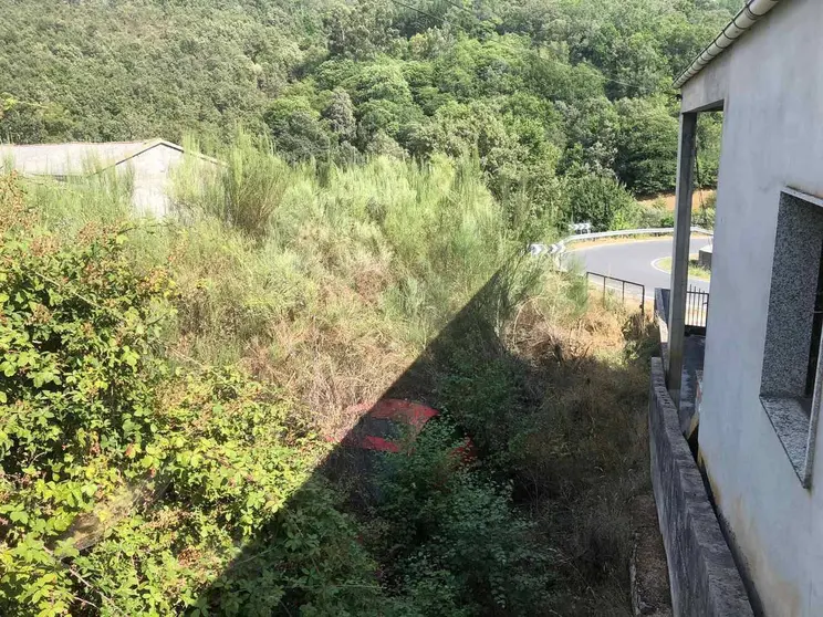 Un dos vehículos abandonados nesta finca de Esperanzo e cuberto de maleza, preto das vivendas.