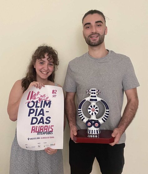Mirian Opazo e Borja Rubén, co cartel desta nova edicións das Olimpíadas Rurais Interpobos e co premio para o gañador.