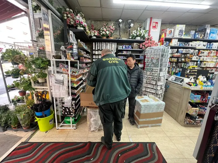 Un agente de la Guardia Civil inspeccionando uno de los bazares.