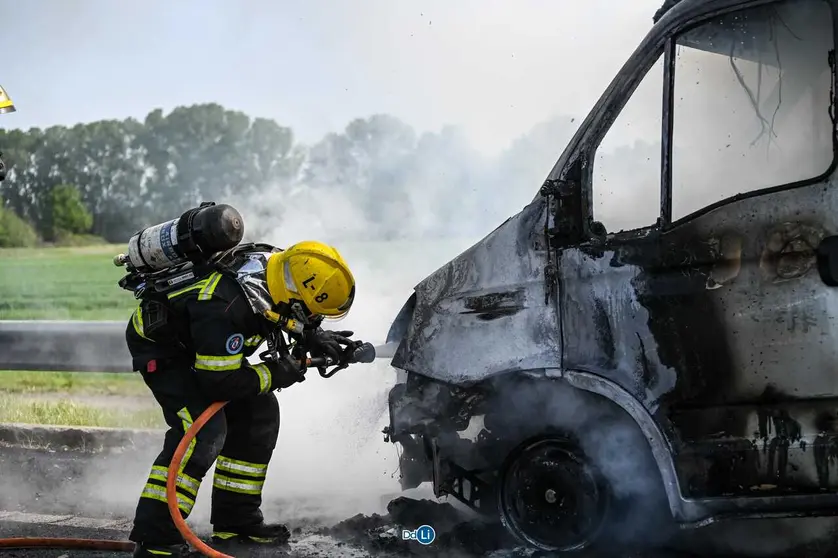 Un bombero del cuerpo de Xinzo de Limia sofocando las llamas del veh&iacute;culo. | Foto: Noelia Caseiro.