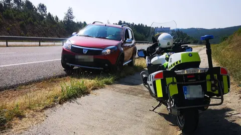 El veh&iacute;culo interceptado, con la motocicleta de uno de los agentes que le dieron el alto.