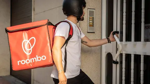 Un repartidor de roombo entrando en un portal da la capital antelana.