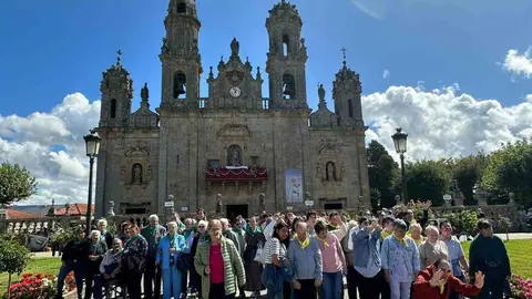 Dos grupos de usuarios posan delante del santuario de Los Milagros.