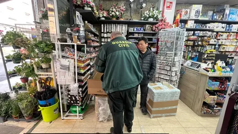 Un agente de la Guardia Civil inspeccionando uno de los bazares.