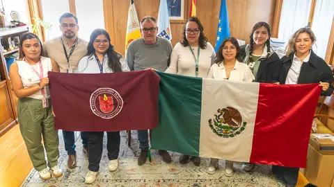 El alcalde Amador D&iacute;az protagoniza una foto de familia junto a la delegaci&oacute;n de estudiantes, quienes portaban las banderas de M&eacute;xico y su universidad durante su recepci&oacute;n.