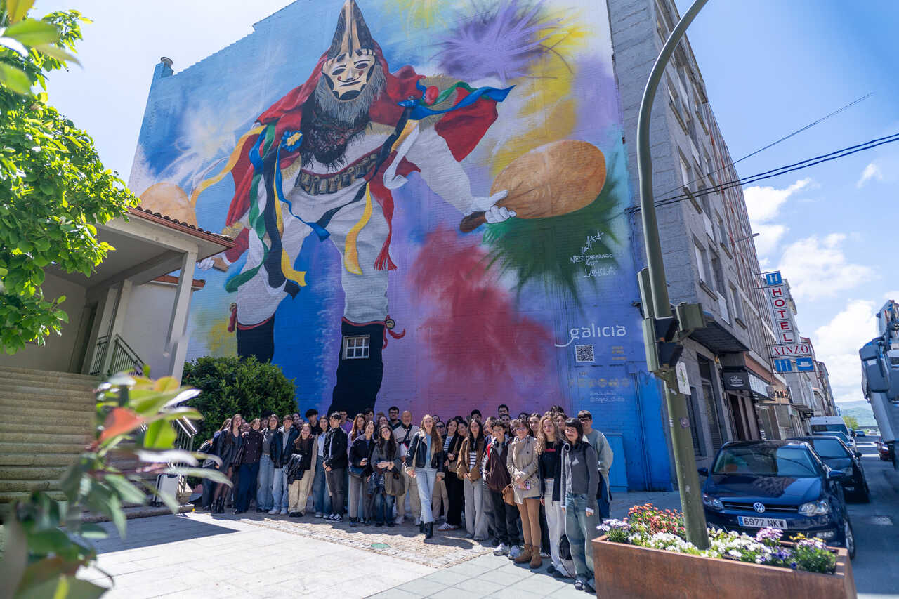 Fotografía institucional de los 50 futuros pedagogos ante el gran mural de la pantalla junto al MUGAE.