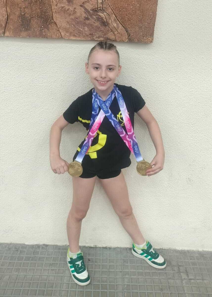 Aira García Teijeiro posa con sus dos medallas de oro del Campeonato de España Base Alevín, logradas en trampolín y minitramp en Granada, representando al Club Burgas de Ourense.